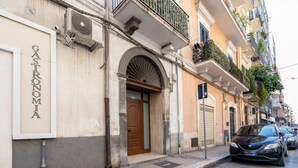 Edifici amb un rètol que diu 'Gastronomia' i un cotxe estacionat al carrer.