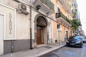 A building with a sign reading 'Gastronomia' and a car parked on the street.