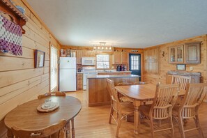 A wooden cabin with a kitchen, dining area, and a large island.