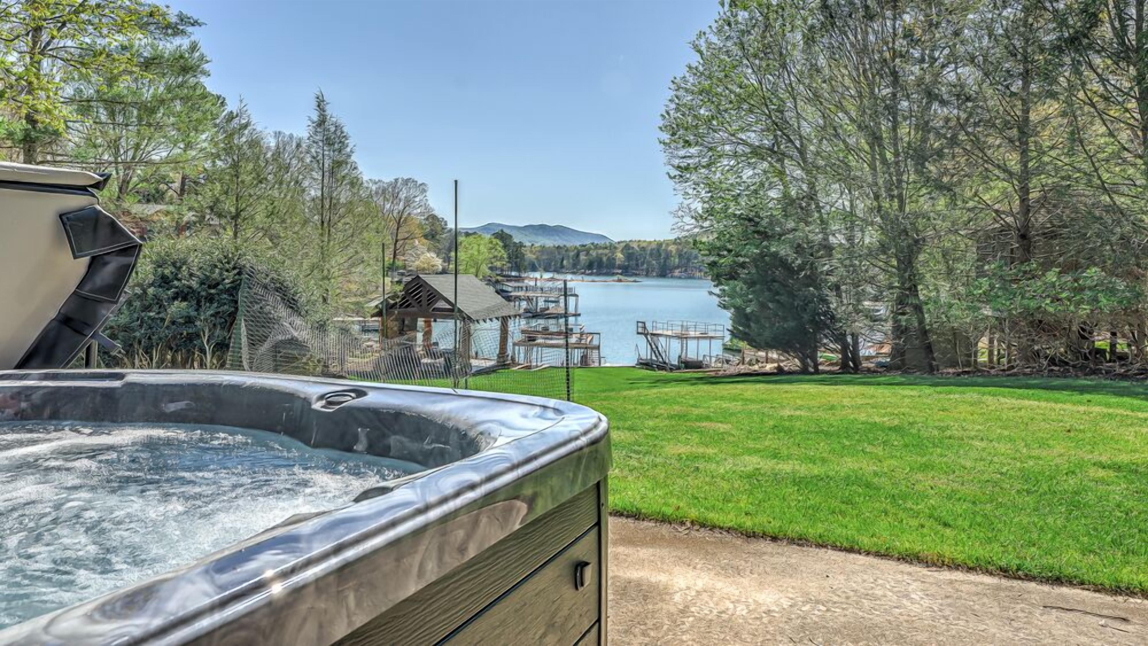 Un jacuzzi en un patio trasero con vistas a un lago y montañas.