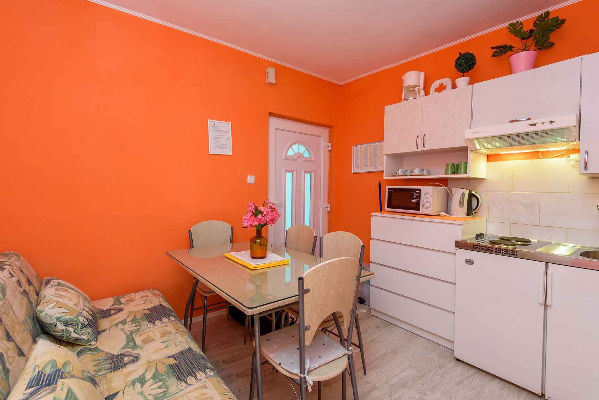 A compact kitchen with white cabinets, a microwave, and a small refrigerator.