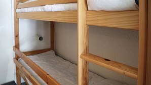 Ein Etagenbett mit zwei Schlafstellen, jeweils mit Kissen und Matratze.