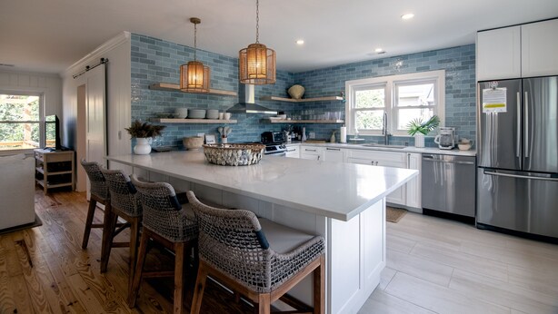 A modern kitchen with a large island, bar stools, and stainless steel appliances. - Making Memories-Pet Friendly Cottage w/ Sun Deck;Easy Beach Access; WiFi/TV (Edisto Beach)