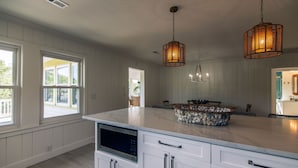 A kitchen with white cabinetry, a marble island, and pendant lighting. - Making Memories-Pet Friendly Cottage w/ Sun Deck;Easy Beach Access; WiFi/TV (Edisto Beach)