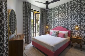 Une chambre à coucher avec un grand lit, une commode, un miroir et des rideaux à motifs.
