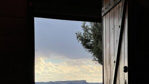 A wooden door opening to a balcony with a view of a mountainous landscape. - Private Sauna and Stunning Views of Mesa Verde, Walk to Mancos State Park (Mancos)