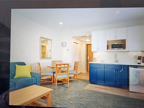 A compact living space with a kitchenette, a dining area, and a seating area with a sofa and chairs. - Luxury Resort with Restaurants , 5 minutes to the beach (West Yarmouth)