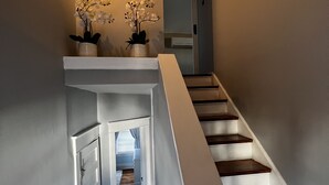 A staircase with white railings and dark wooden steps leading to a door. - Historic three-level home in the Highlands (Louisville)