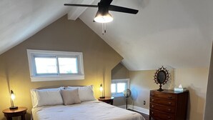A bedroom with a bed, a dresser, a globe, and a ceiling fan. - Historic three-level home in the Highlands (Louisville)