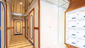 A hotel hallway with wooden flooring, white walls, and a modern ceiling design. - Le chant de la mer by Interhome (Fréjus)