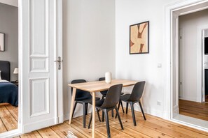 Enjoy meals at the dining table with four chairs, accompanied by a vase and artwork.