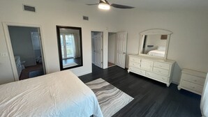 Une chambre à coucher avec un lit, une commode et un ventilateur de plafond.