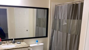Een badkamer met een wit wastafel, toilet en douchegordijn.