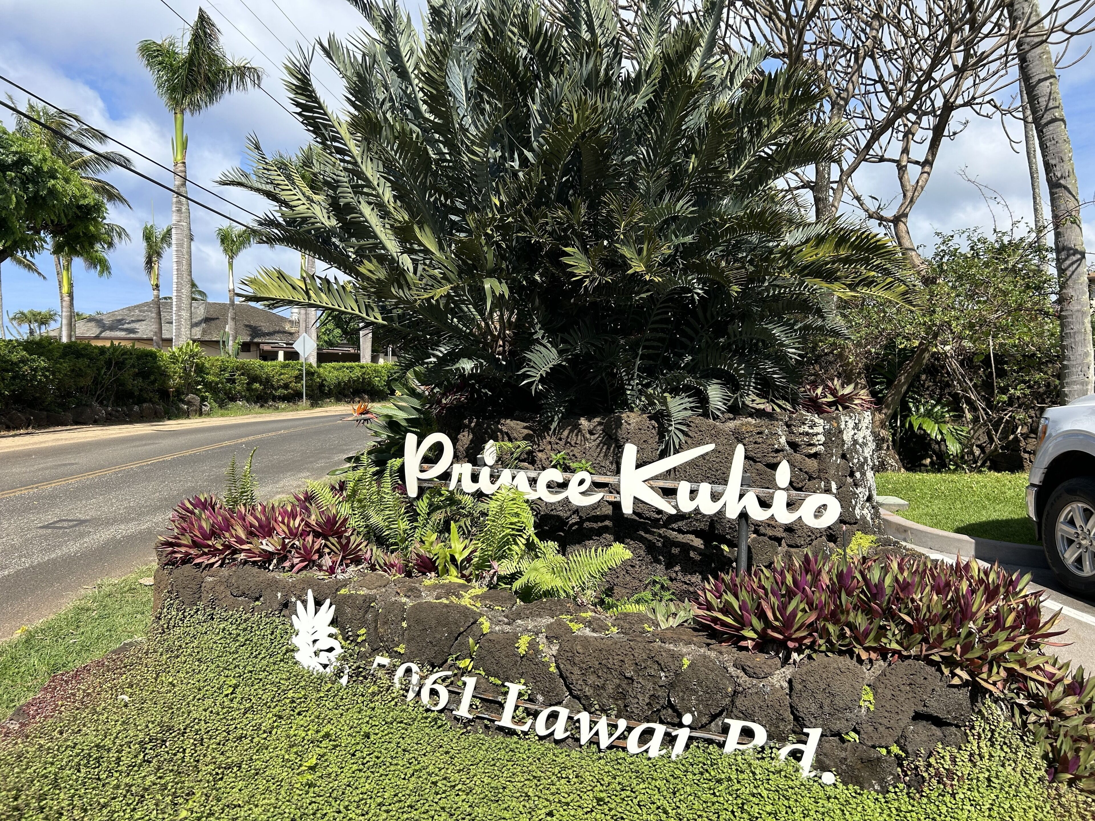 Une plaque commémorative en l’honneur du prince Kuhio, située au 961, Kawailani Road, agrémentée d’un jardin tropical et de palmiers.