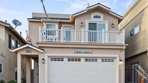 A two-story house with a garage, a balcony, and a satellite dish. - Coastal Haven w/ Large Rooftop Deck & Beach Access 🏖️ (Oceano)