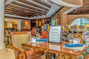 A dining area with a table set for two, a sign indicating WaterScapes is open daily, and a view of the lower level.
