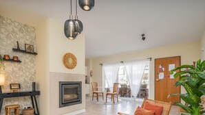 A living room with a fireplace, a dining area, and a view of the outside. - Cozy Retreat for Couples in Burgau (Burgau)