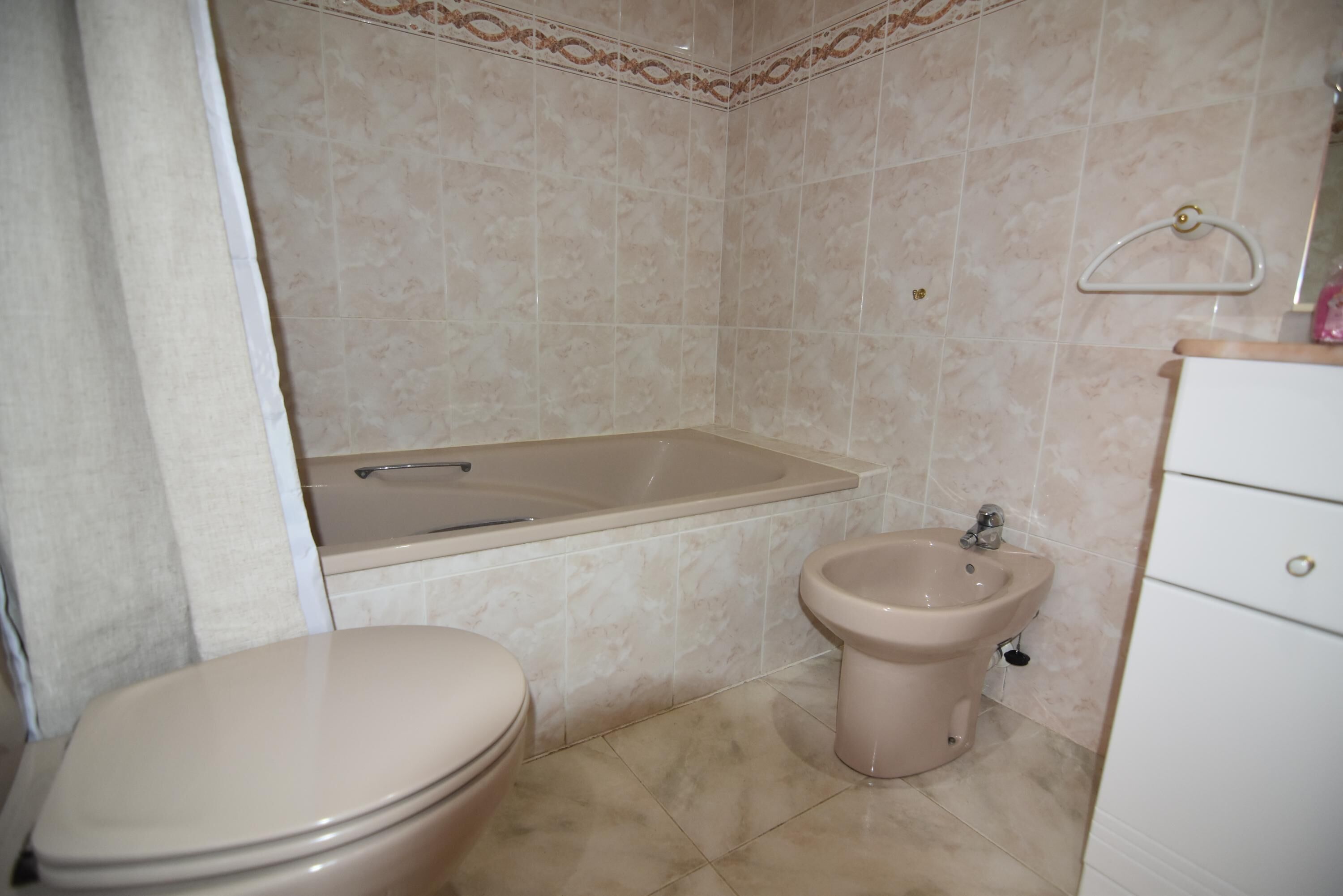 A bathroom with a toilet, a bidet, and a bathtub.