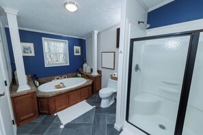 Une salle de bain Ă©quipĂ©e dâune baignoire, de toilettes et dâun espace douche.