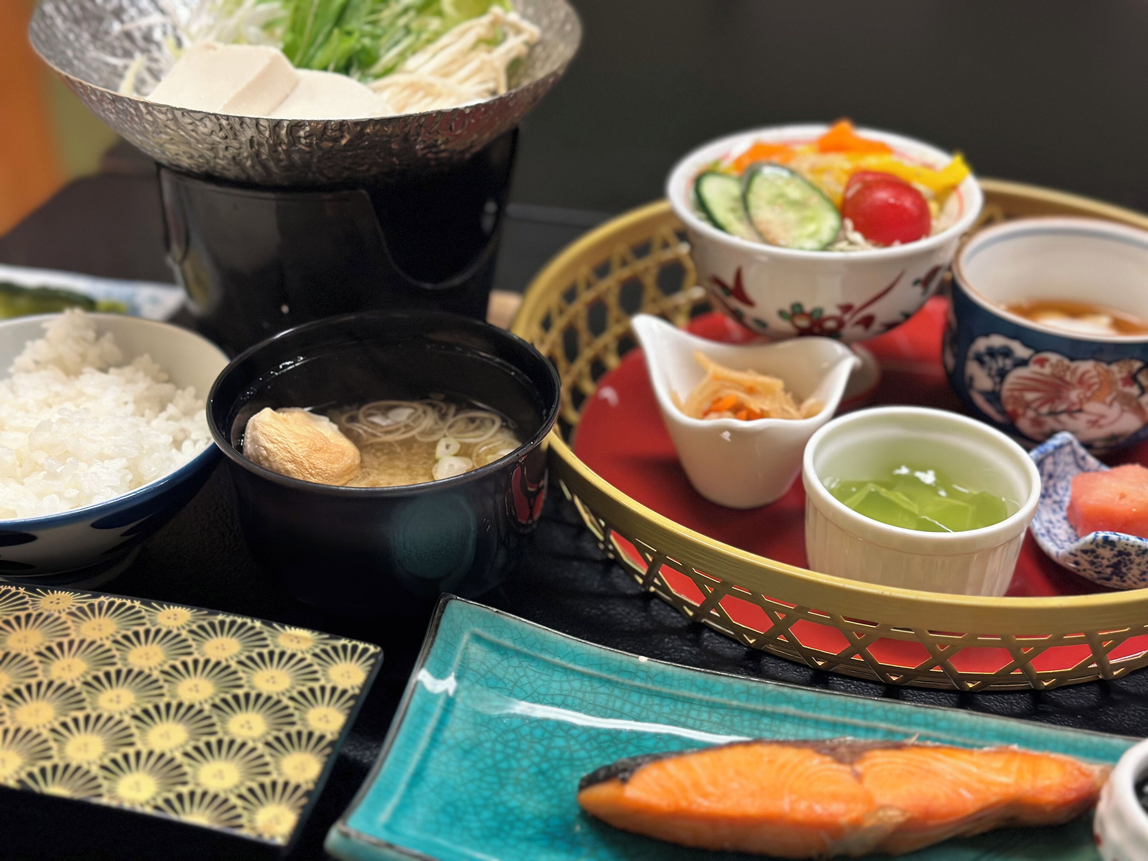 Un repas japonais traditionnel, composé de différents plats, notamment du riz, de la soupe et du sashimi.