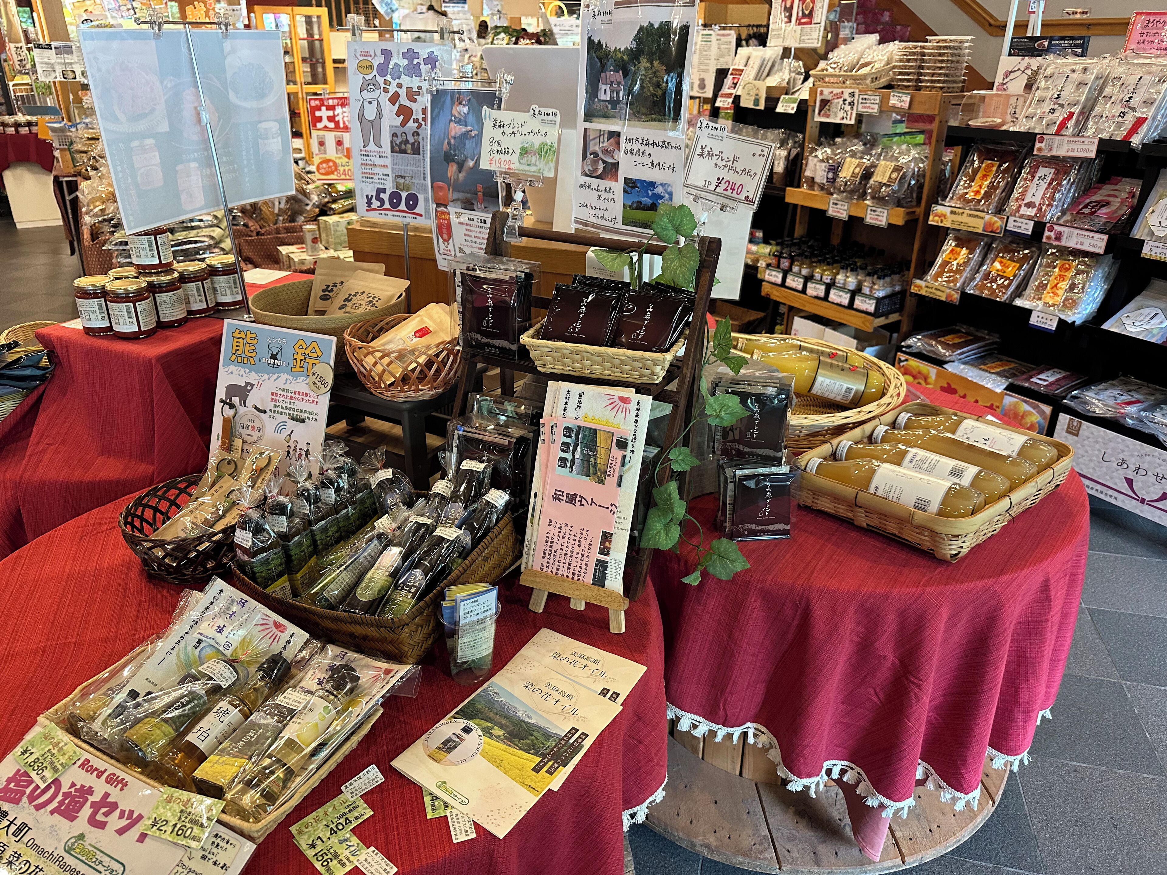 A display of various packaged goods, including food items and possibly gift packages, arranged on tables with red cloths.