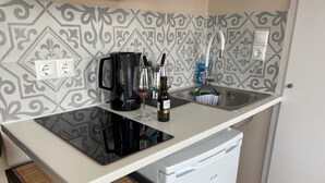 A compact kitchen with a Bosch coffee maker, a sink, and a white refrigerator. - Cozy apartment in heart Athens near metro Fix 100m (Athina)