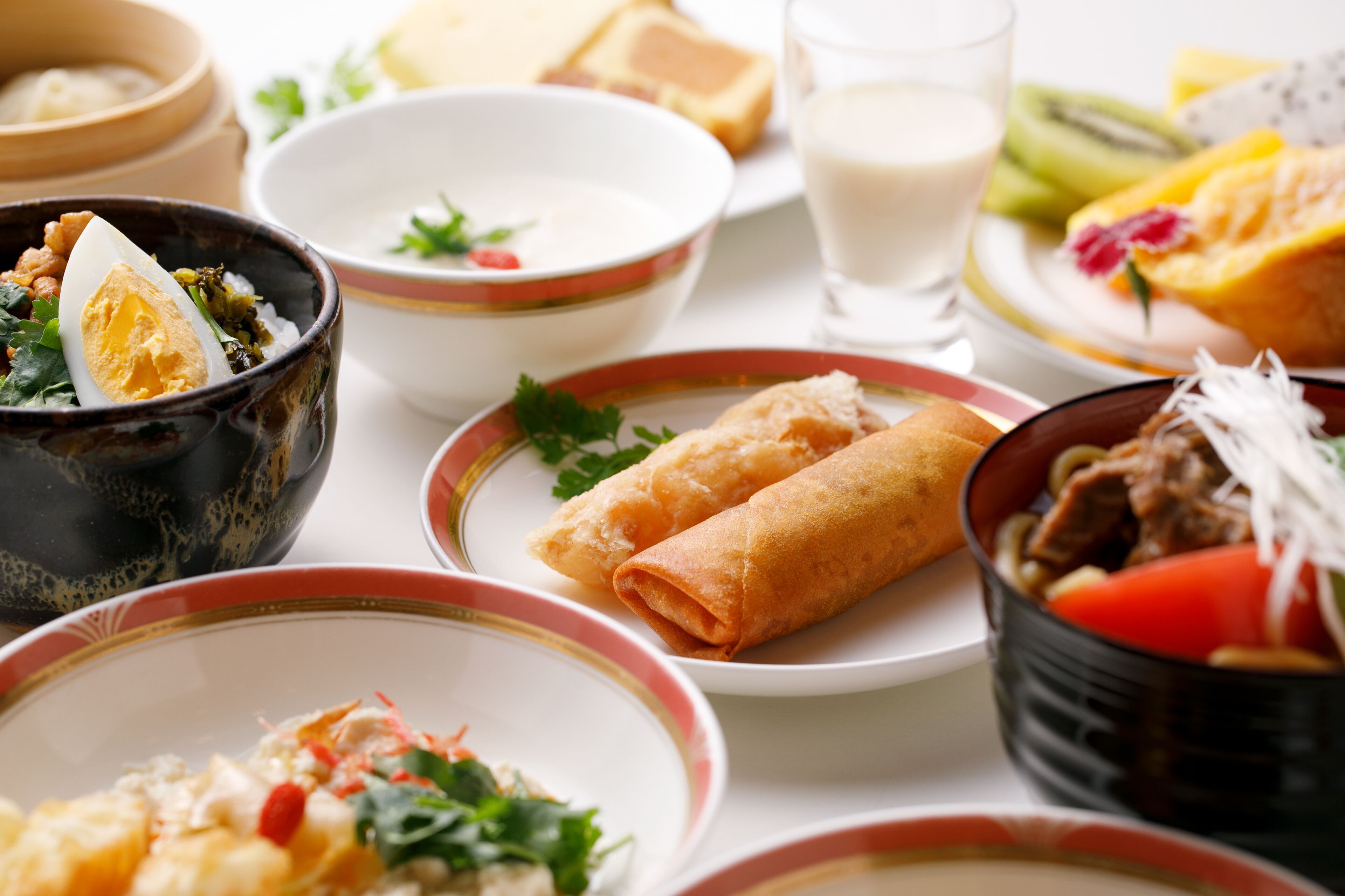 A variety of dishes including soup, rolls, and a bowl of meat with vegetables.