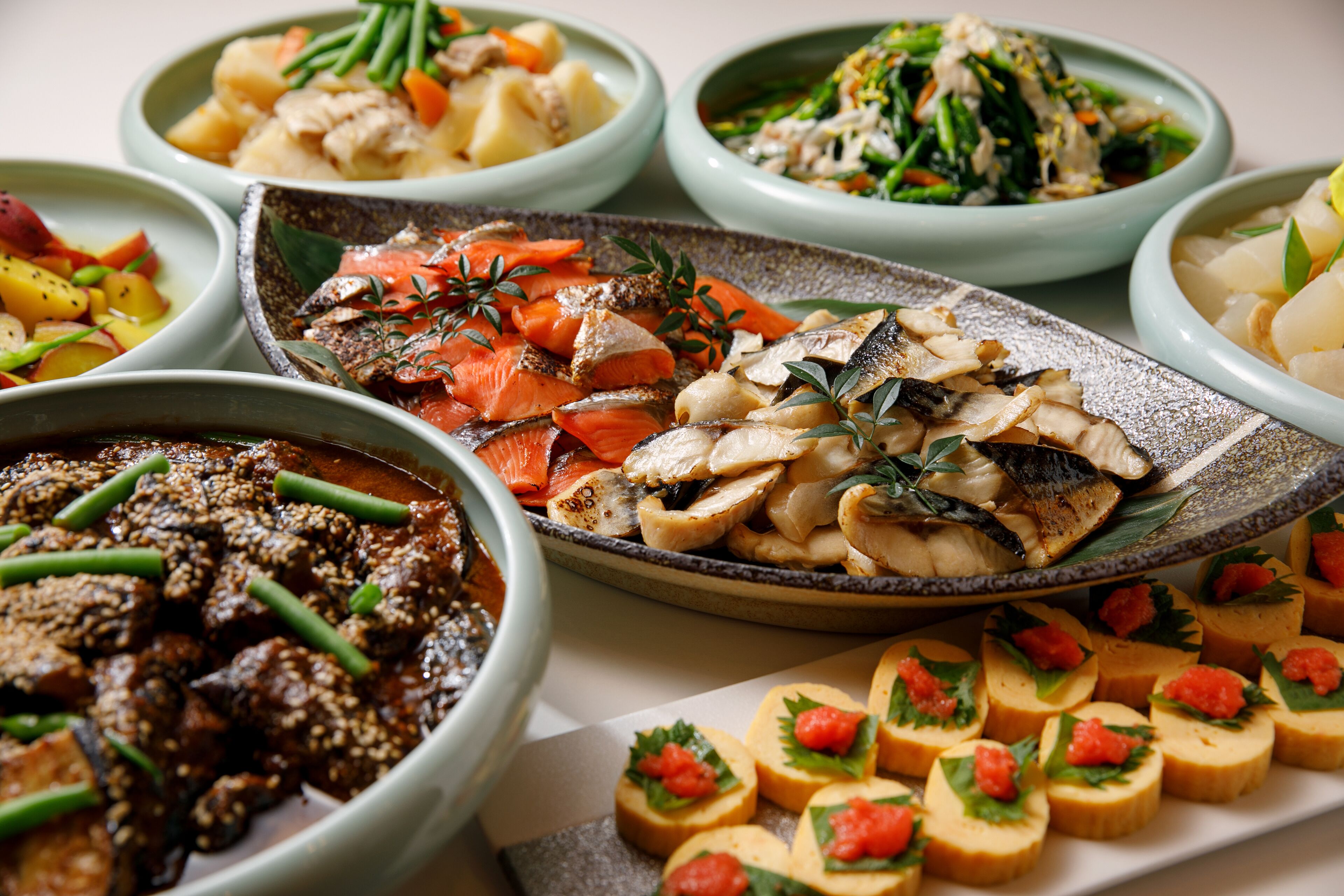 A variety of dishes in different bowls, including seafood, vegetables, and a dessert.