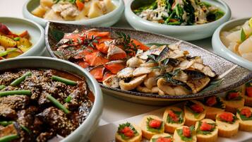 Variedad de platos en diferentes tazones, incluyendo mariscos, verduras y un postre.