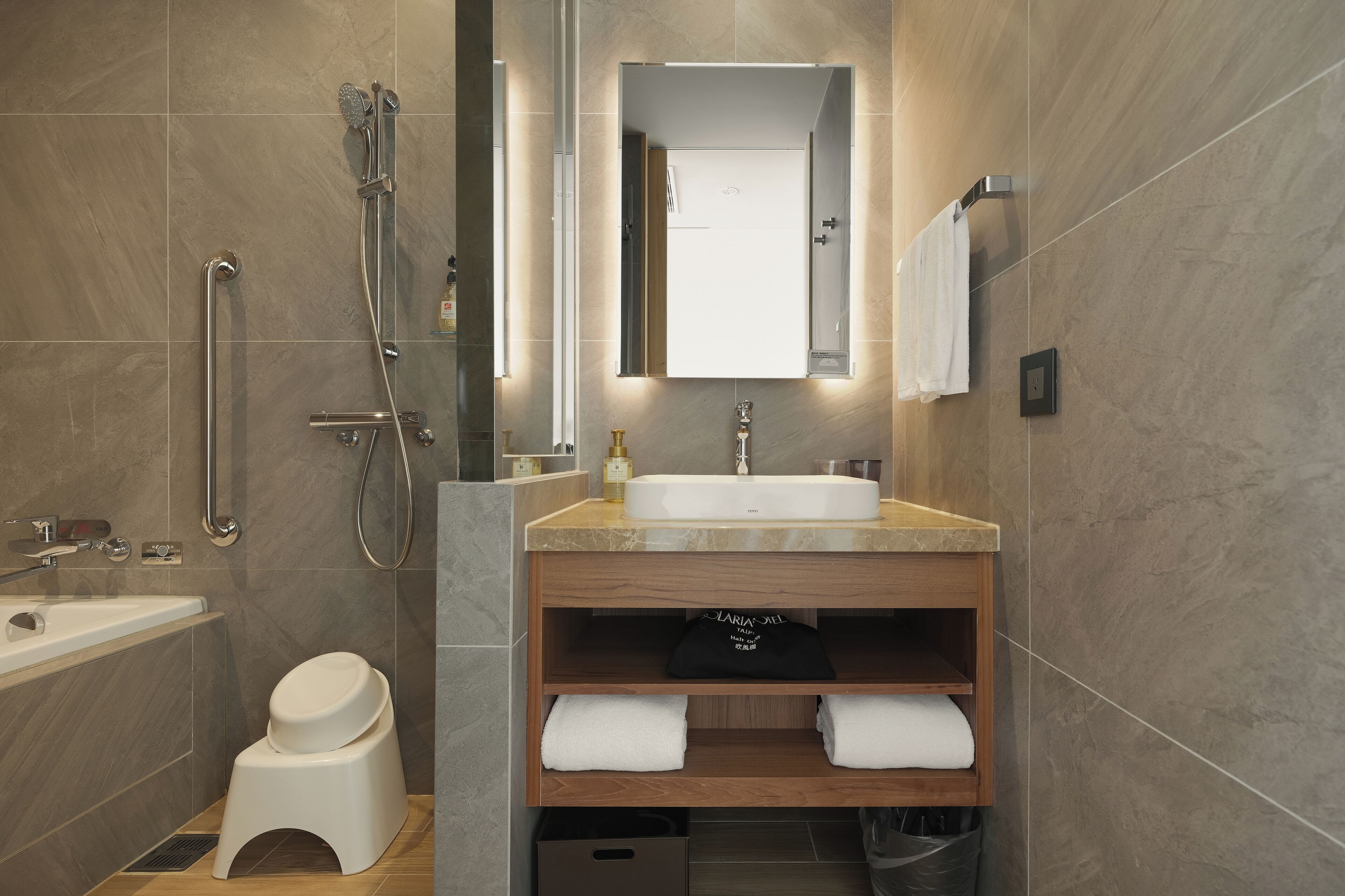 A modern bathroom with a bathtub, a shower, a toilet, and a vanity with a sink and mirror.