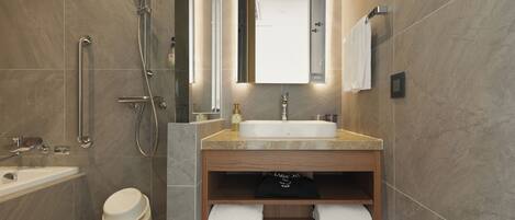 A modern bathroom with a bathtub, a shower, a toilet, and a vanity with a sink and mirror.