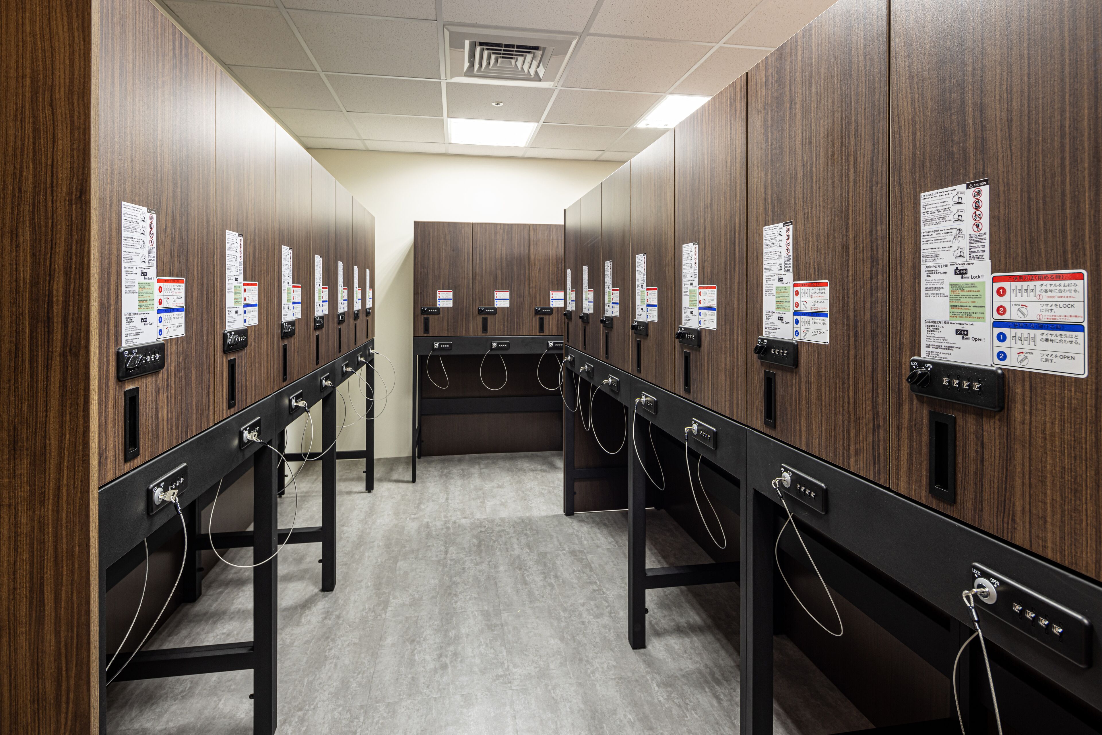 A row of wooden lockers with multiple compartments, each with a lock and a small sign with instructions.