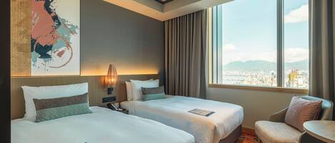 A hotel room with two beds, a desk, a chair, and a large window offering a city view.