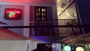Ein Gebäude mit einem Neonlichtschild, auf dem 'Dave's Suite Open 24hrs' steht.