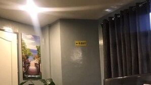 Ein Hotelzimmer mit Bett, Kissen, Handtuch, einem Hinweisschild für einen Notausgang und einer Tür.