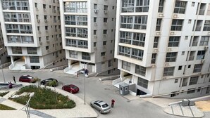 Un edificio residenziale a più piani con un cortile centrale, un percorso pedonale e un’area di parcheggio.