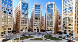 A modern residential building complex with multiple high-rise apartments, a central courtyard, and a parking area.