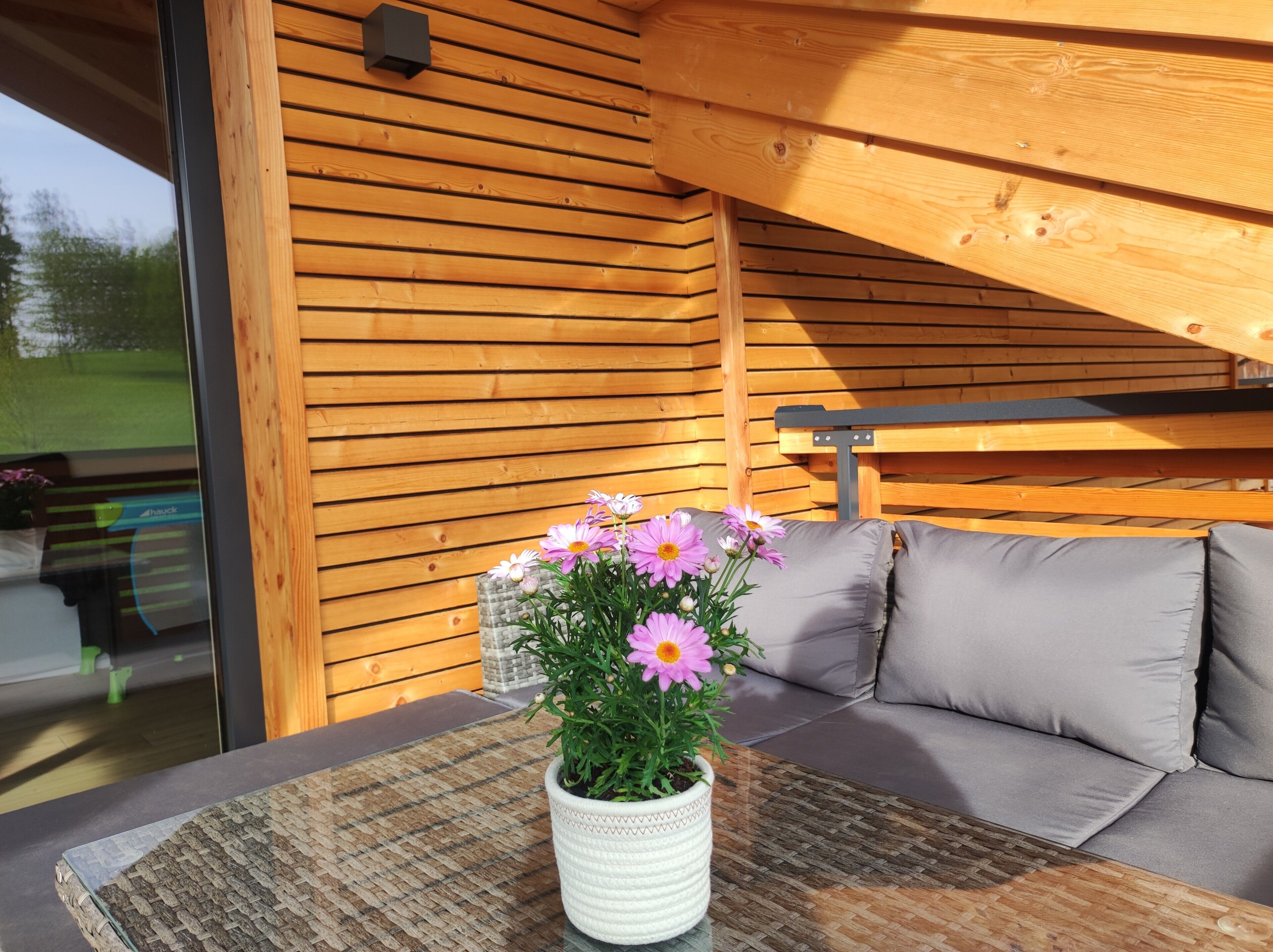 Un intérieur en bois avec un canapé et une table sur laquelle est posée une plante en pot.