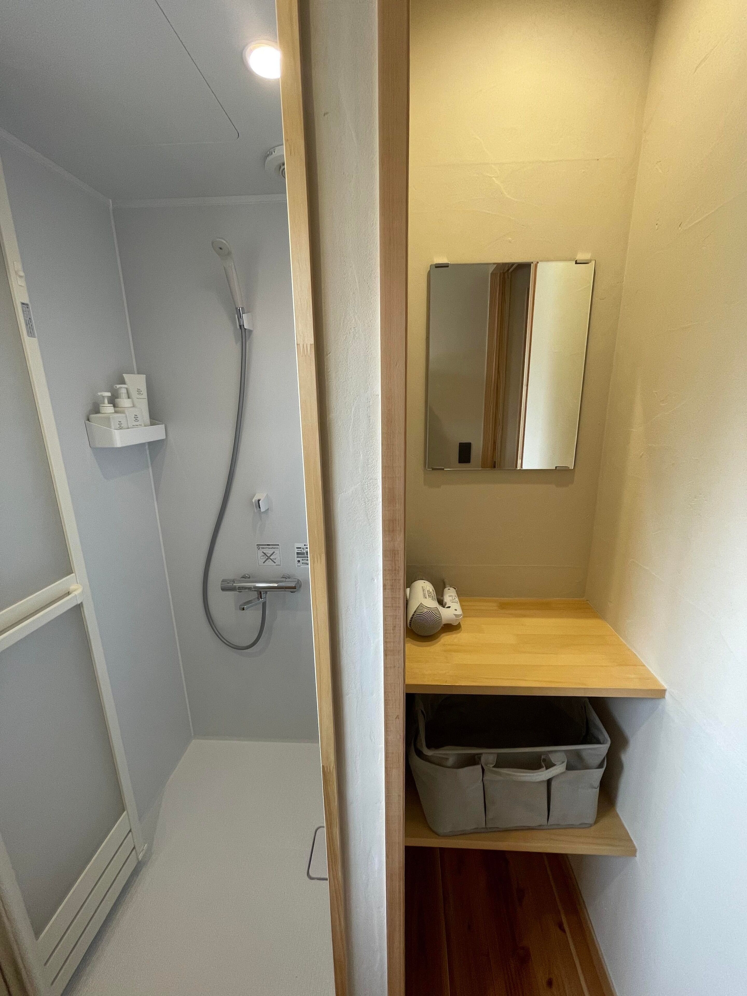 Ein Badezimmer mit Dusche, Spiegel und Ablageflächen.