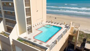 Une piscine sur le toit offrant une vue sur la plage et l’océan.