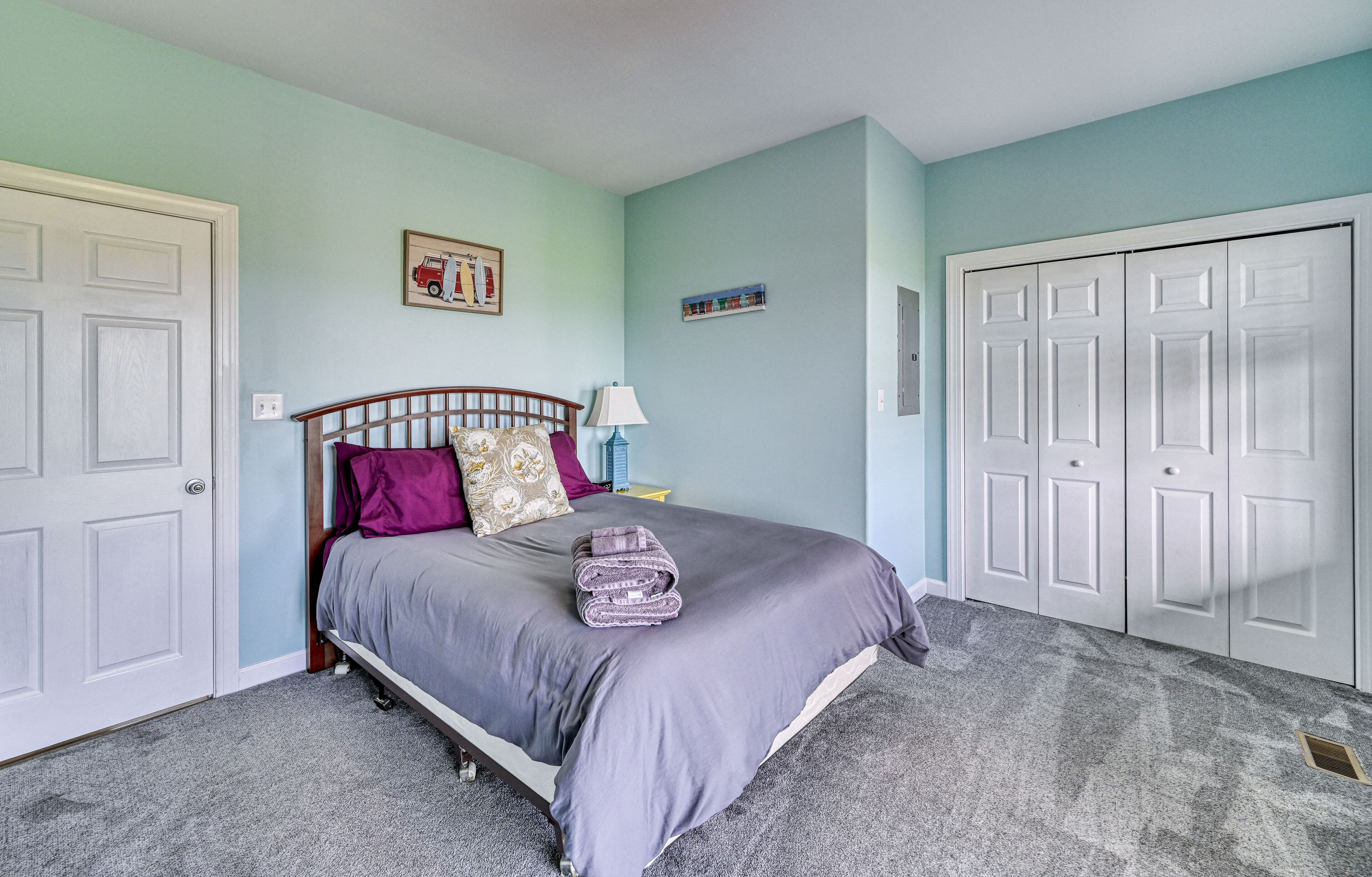 Une chambre à coucher avec un lit, une table de chevet, une lampe et une armoire.