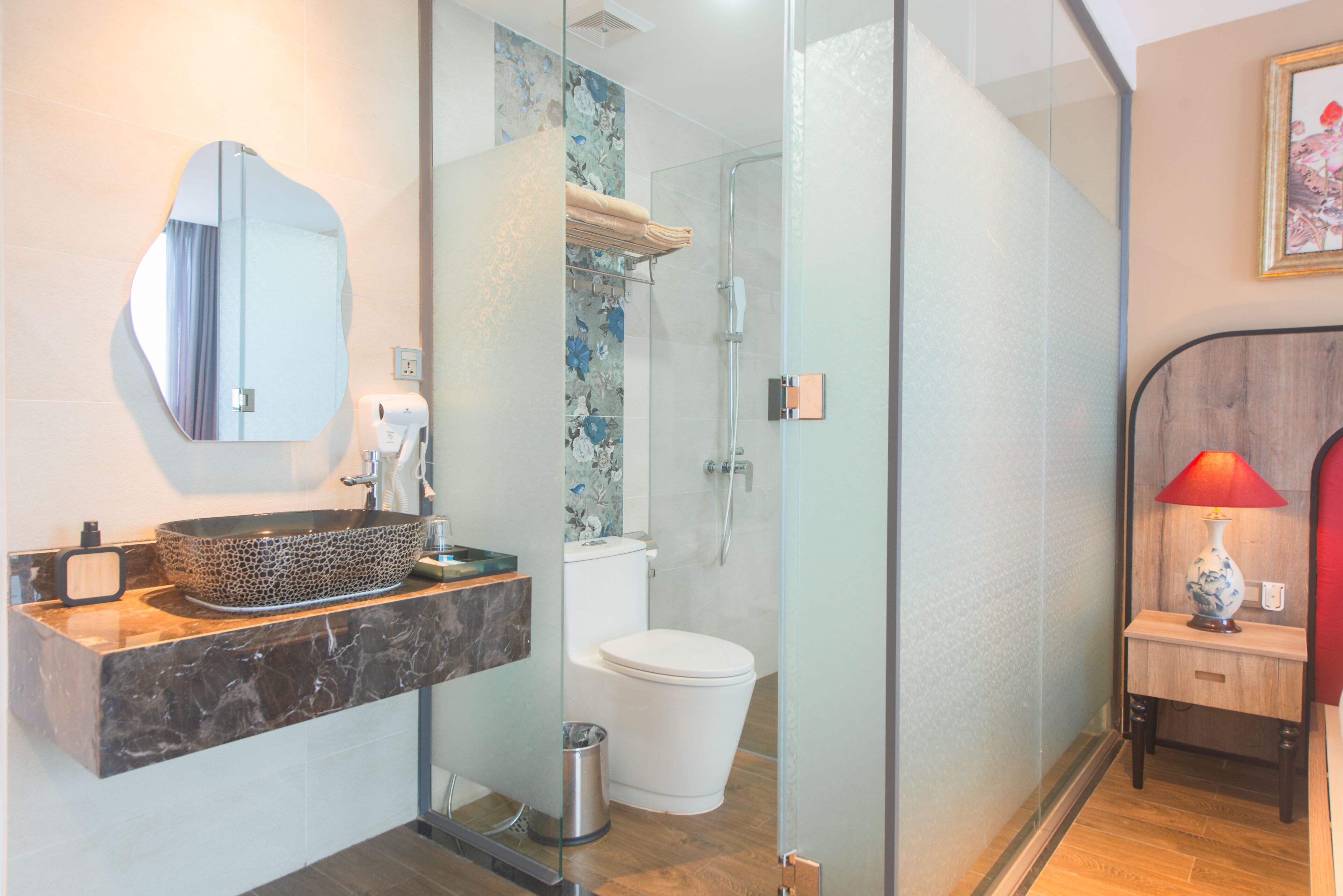 Un bany modern amb dutxa envidriada, un lavabo de marbre i un vàter.