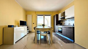 Eine moderne Küche mit Essbereich, Fernseher und Fenster.