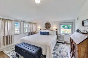 Cozy retreat with a large bed, bedside tables, and a desk, offering a comfortable space to unwind.