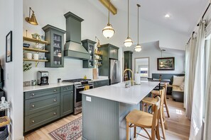 Enjoy meals and socializing at the central island with bar stools, surrounded by sleek cabinetry and pendant lights.
