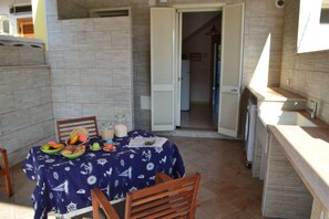 Enjoy meals for two in this cozy dining area with a table set and a view of the adjacent room.