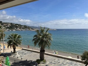 A coastal view with a promenade, palm trees, and a marina. - Petit Bijou les Pieds Dans L'eau Pour des Vacances de Rêve ! (Le Lavandou)