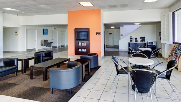 A modern waiting area with seating, a vending machine, and a small kitchenette.
