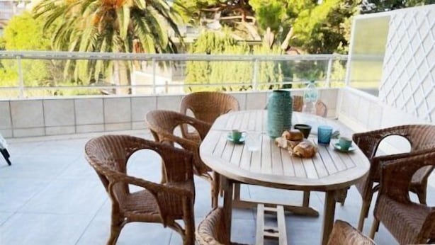 A round wooden table with wicker chairs on a balcony. - Bel Appartement 3 Pièces Climatisé 400m des Plages (CAVALAIRE SUR MER)