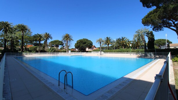 A rectangular swimming pool with a white tiled deck and metal ladder. - Studio for 2 people in the heart of Saint-Tropez (ST TROPEZ)